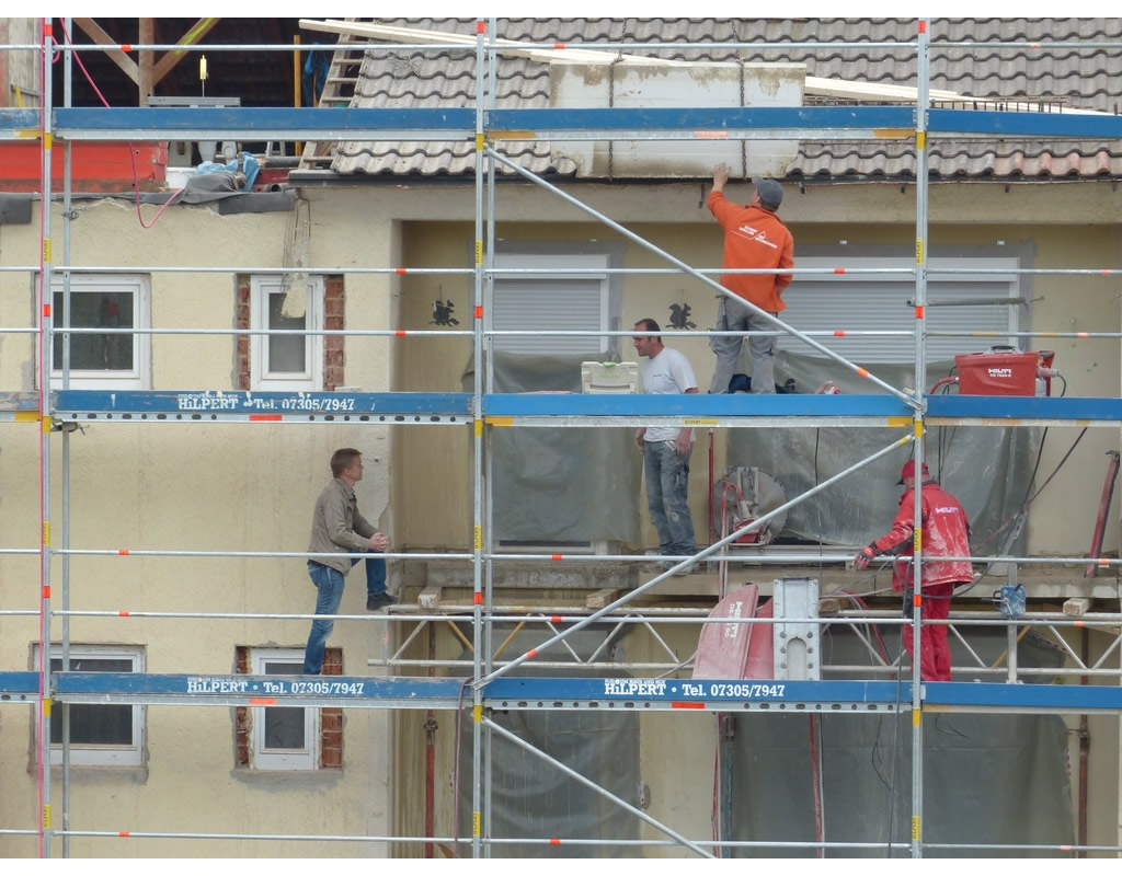 Travailleurs en train d'effectuer le ravalement d'un immeuble